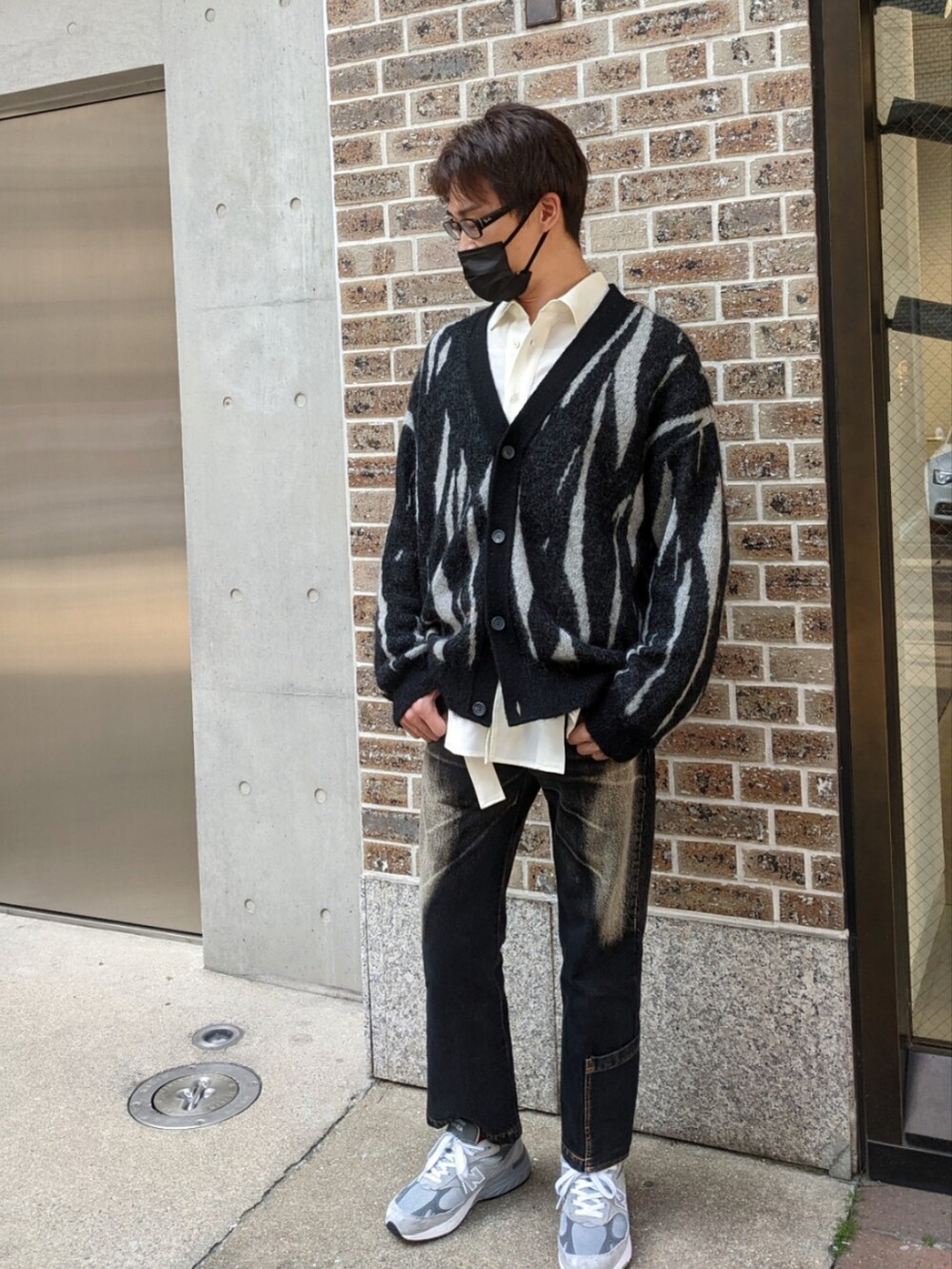 グレー系のスニーカー、ブラック系のカーディガン/ボレロを着用したメンズの春コーディネートの3枚目の写真