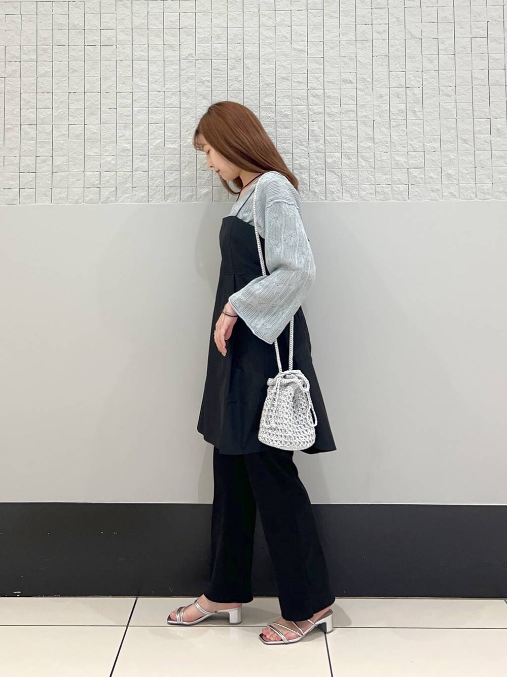 ブラック系のシャツ/ブラウス、ブラック系のスラックス、グレー系のショルダーバッグを着用したレディースの春コーディネートの3枚目の写真