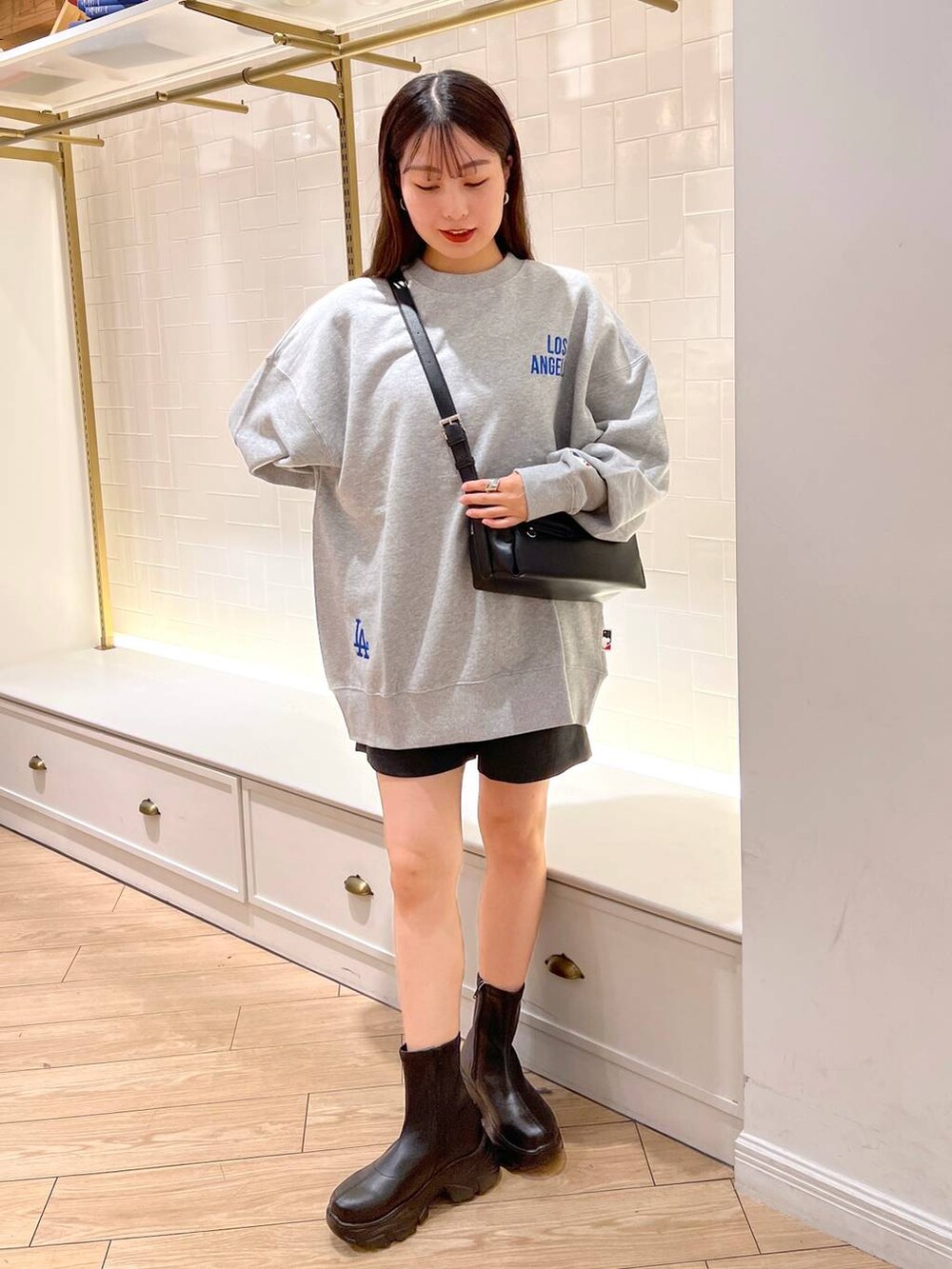 ブラック系のブーツ、グレー系のその他パンツ、ブラウン系のショルダーバッグを着用したレディースの秋コーディネートの4枚目の写真