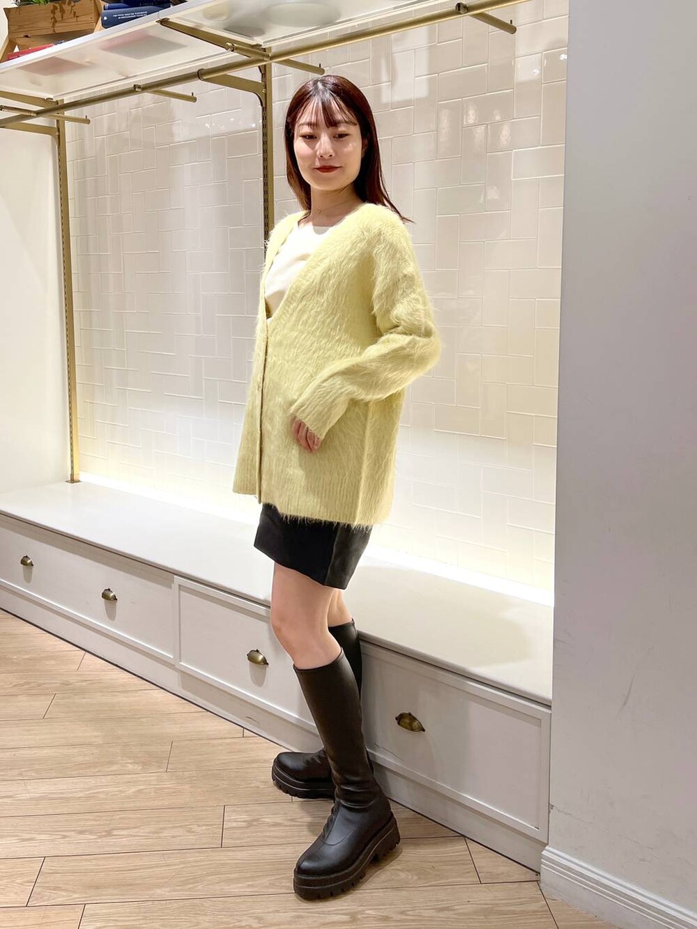 ホワイト系のニット/セーター、ブラック系のその他パンツ、ブラック系のブーツを着用したレディースの秋コーディネートの3枚目の写真