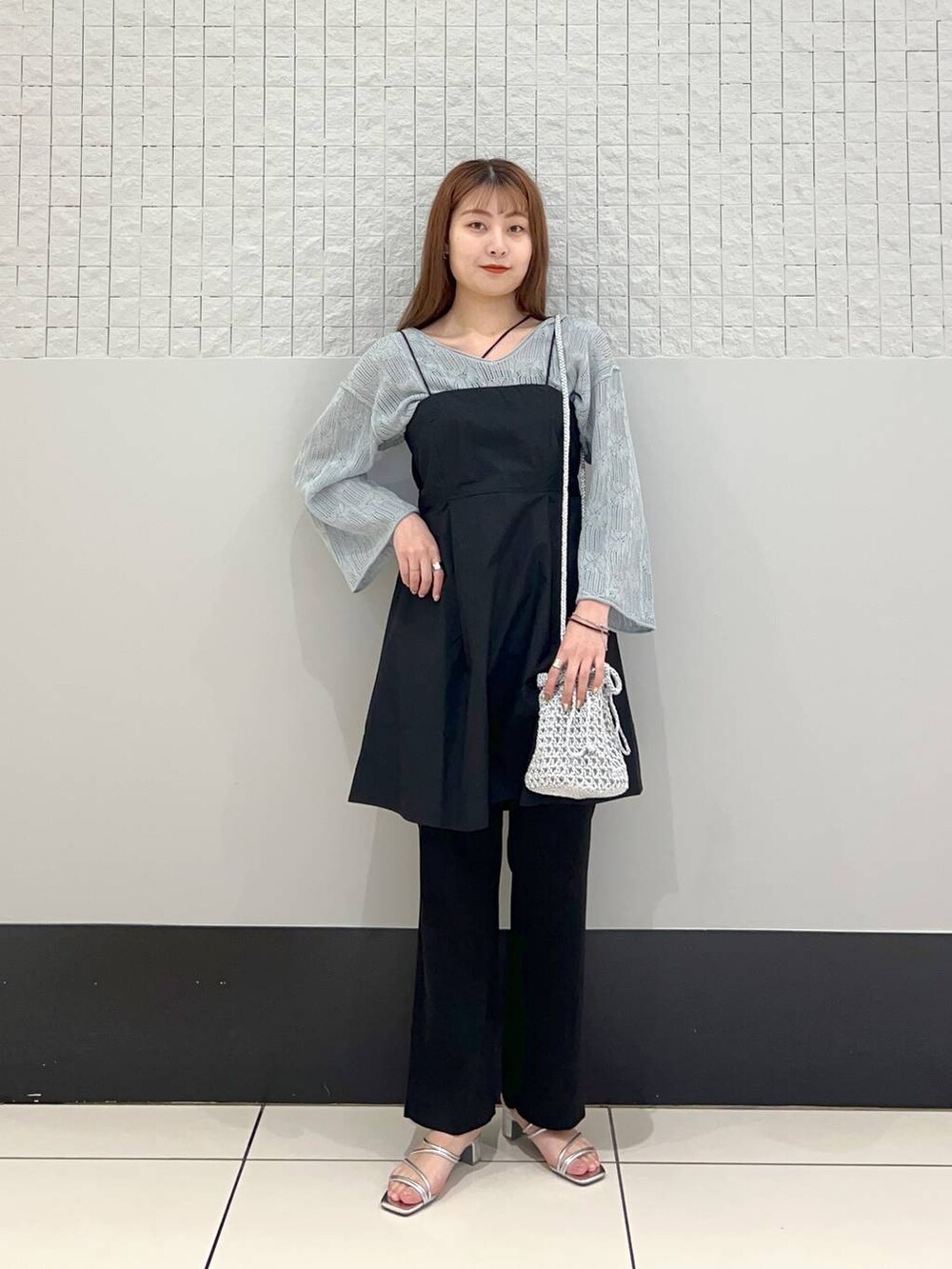 ブラック系のシャツ/ブラウス、ブラック系のスラックス、グレー系のショルダーバッグを着用したレディースの春コーディネートの2枚目の写真