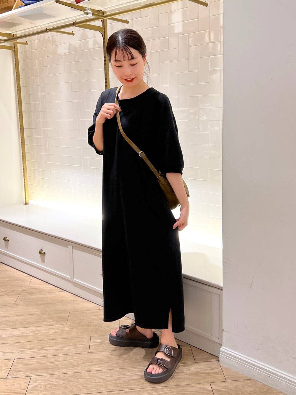 ブラウン系のサンダル、ブラック系のワンピース、ブラウン系のショルダーバッグを着用したレディースの夏コーディネートの4枚目の写真