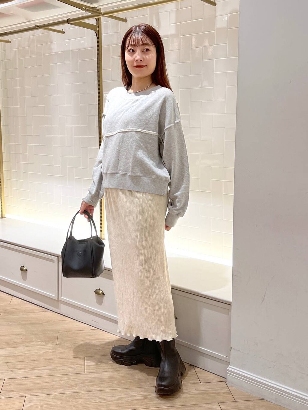 ブラック系のブーツ、グレー系のスウェット、ブラック系のショルダーバッグを着用したレディースの秋コーディネートの3枚目の写真