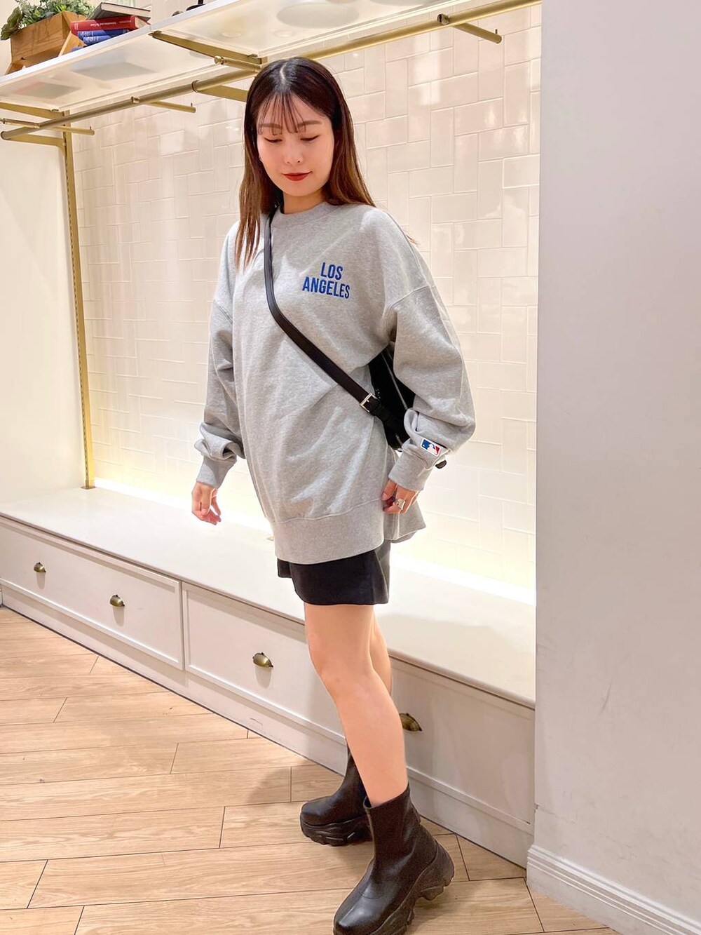 ブラック系のブーツ、グレー系のその他パンツ、ブラウン系のショルダーバッグを着用したレディースの秋コーディネートの5枚目の写真