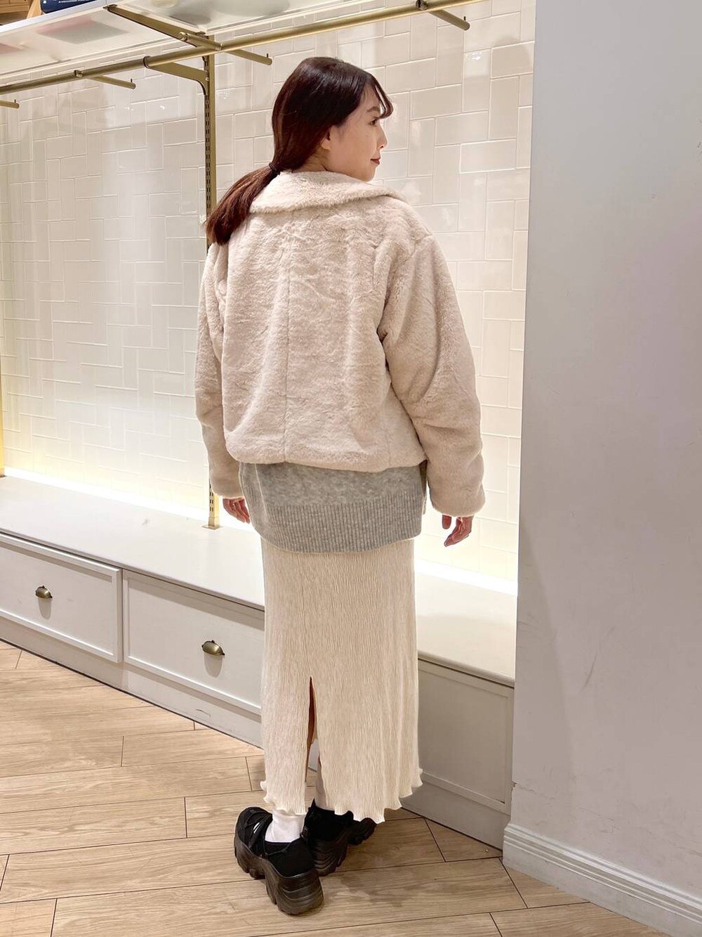 ホワイト系のブルゾン、ブラック系のスニーカー、ホワイト系のスカートを着用したレディースの秋コーディネートの4枚目の写真