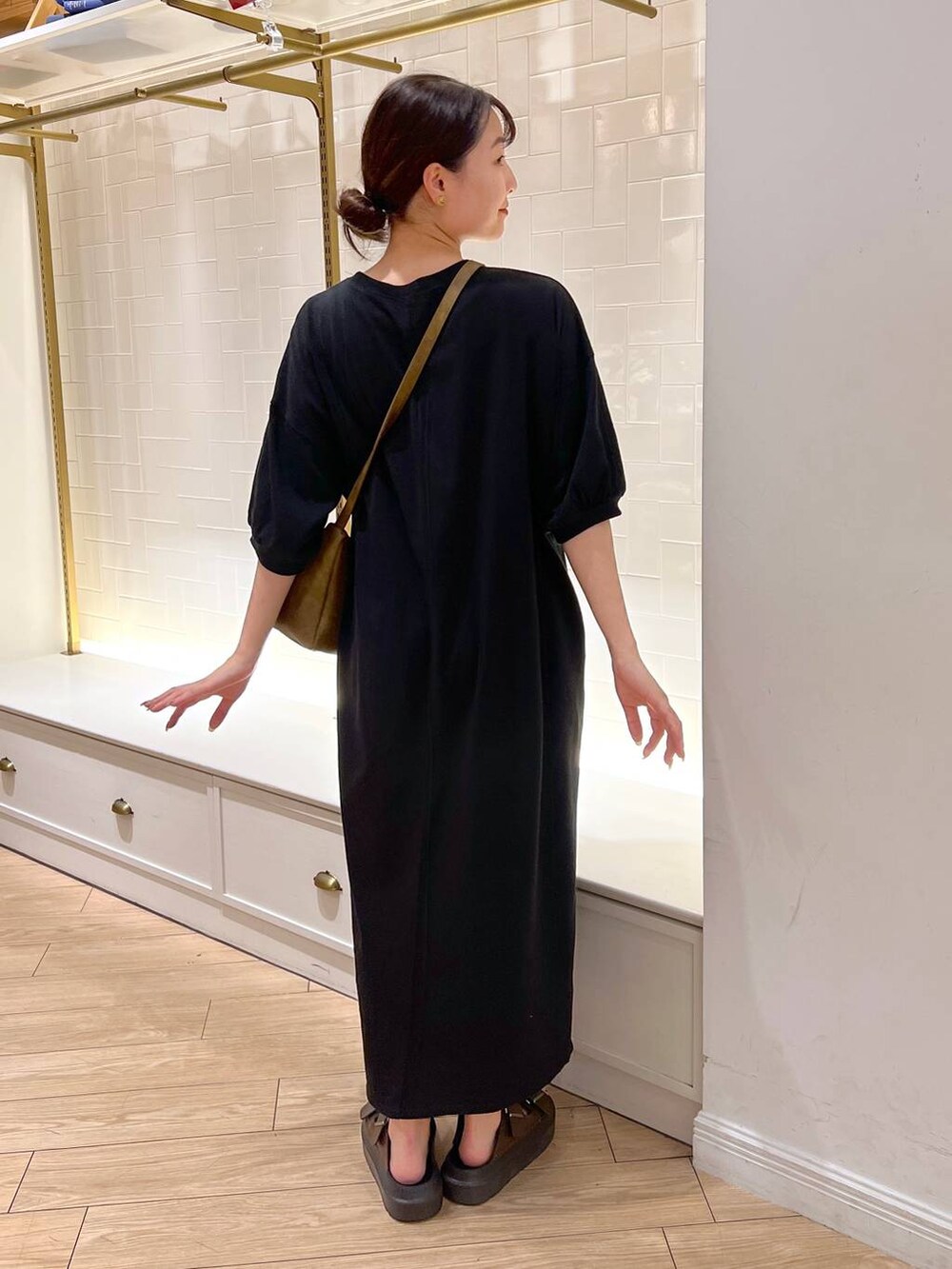 ブラウン系のサンダル、ブラック系のワンピース、ブラウン系のショルダーバッグを着用したレディースの夏コーディネートの5枚目の写真