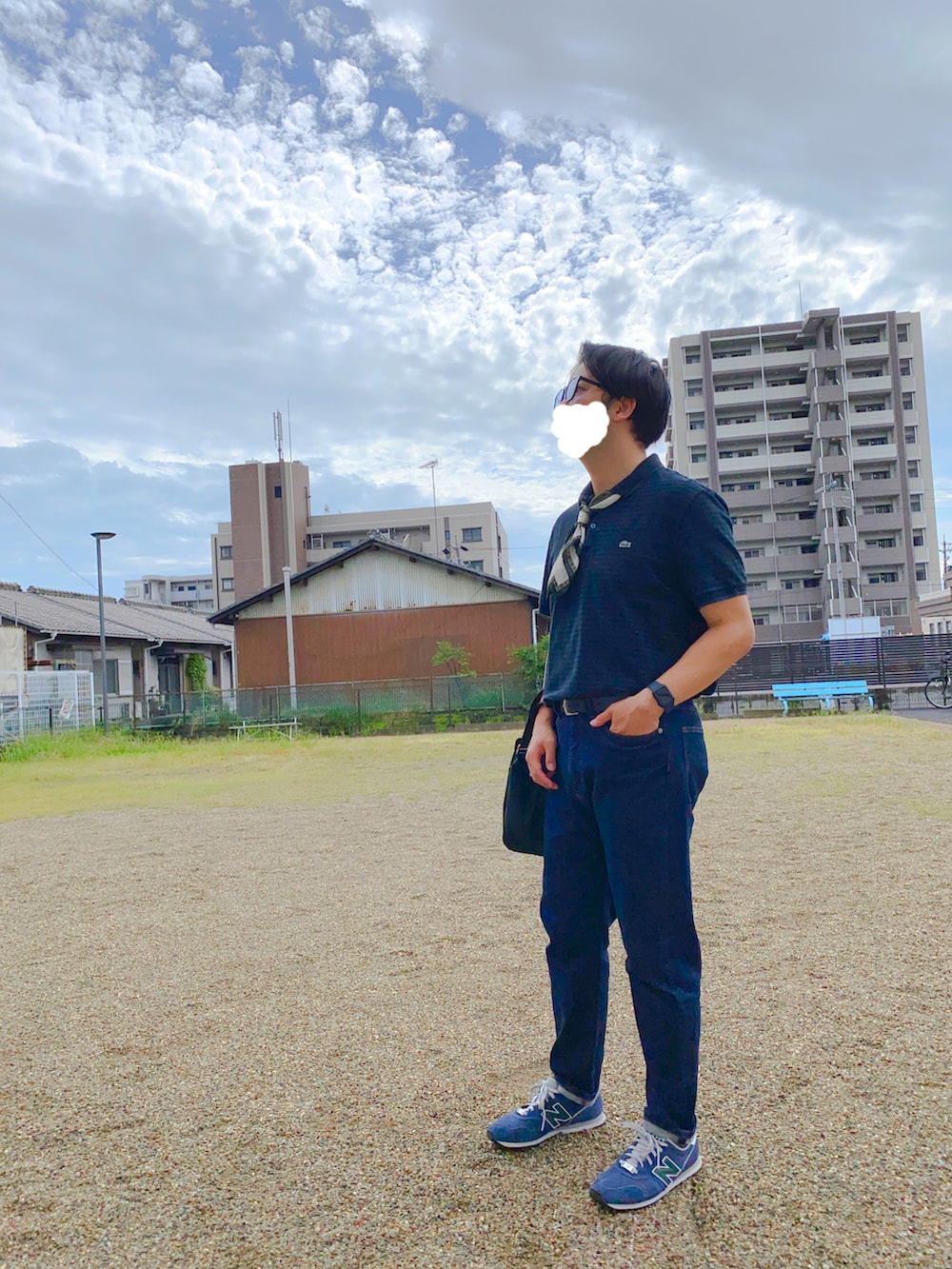 ブラック系のハンドバッグ、ブルー系のデニムパンツ、ブルー系のスニーカーを着用したメンズの秋コーディネートの2枚目の写真