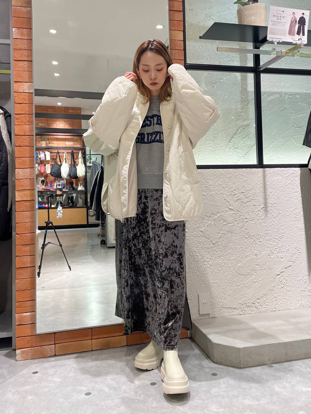 ホワイト系のブルゾン、グレー系のスウェット、グレー系のスカートを着用したレディースの冬コーディネートの2枚目の写真