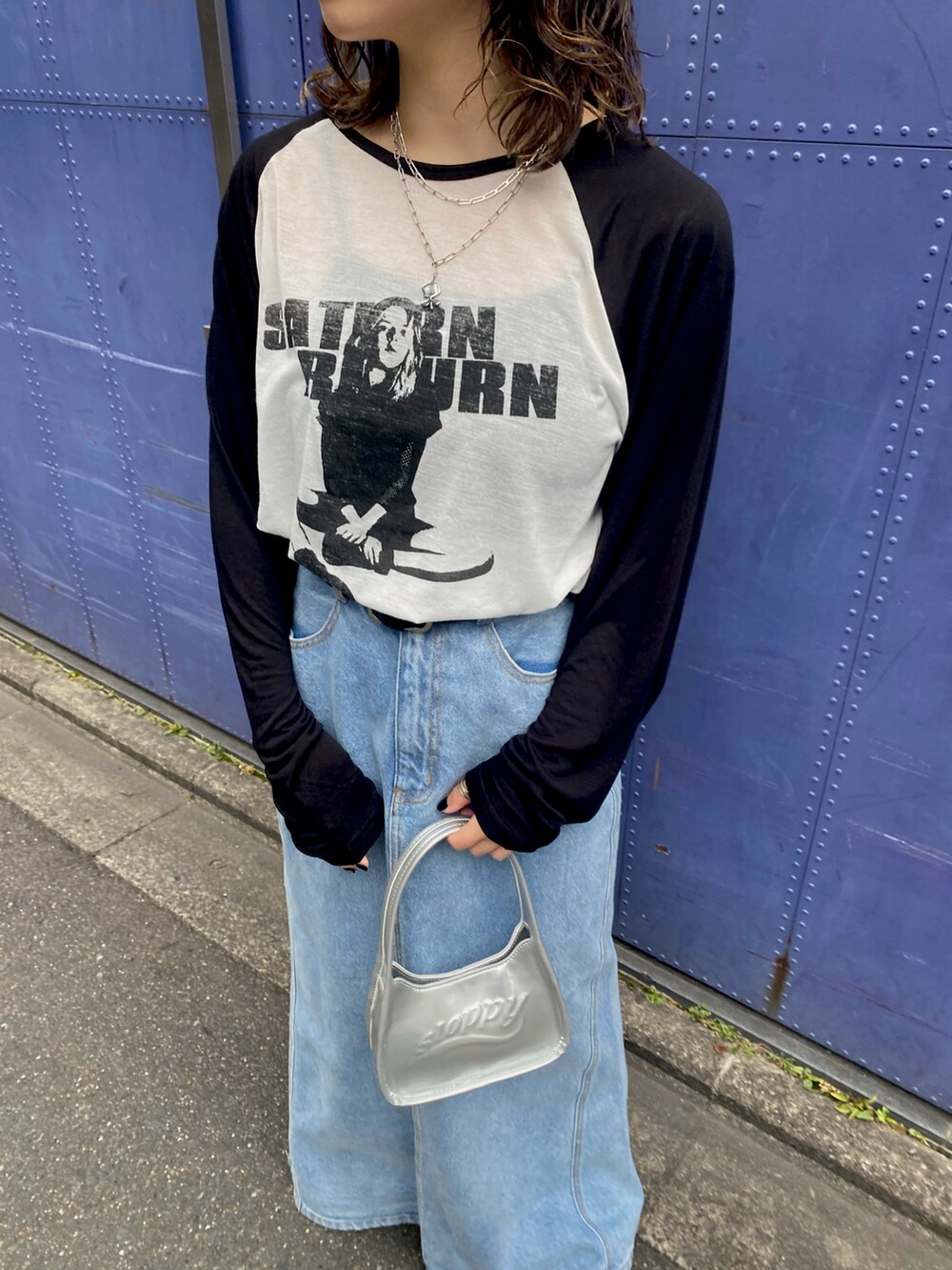 ブラック系のTシャツ/カットソー、シルバー系のハンドバッグ、ブルー系のスカートを着用したレディースの春コーディネートの2枚目の写真