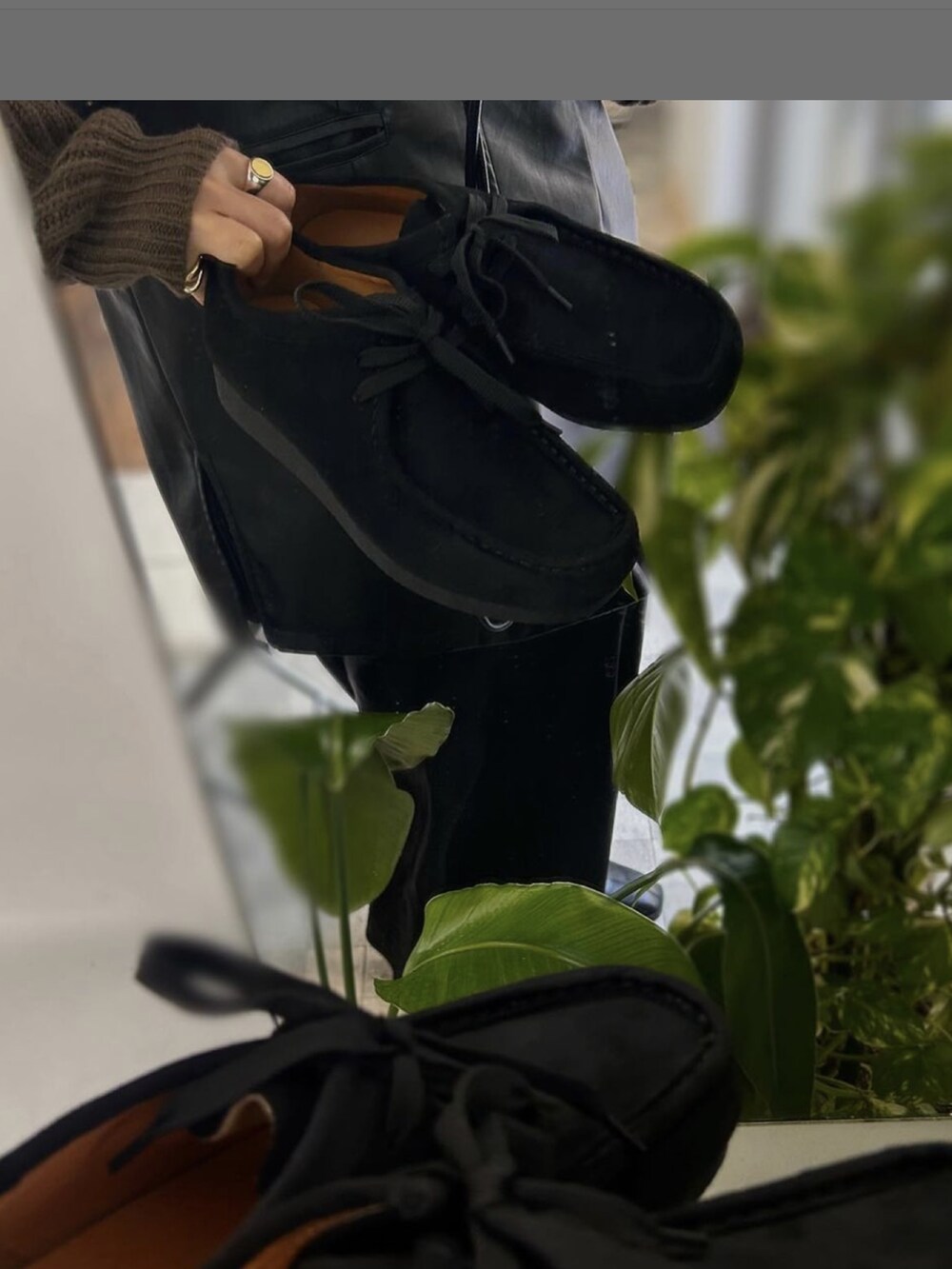 ブラック系のニット/セーター、ブラック系のモカシン/デッキシューズを着用したレディースの冬コーディネートの2枚目の写真