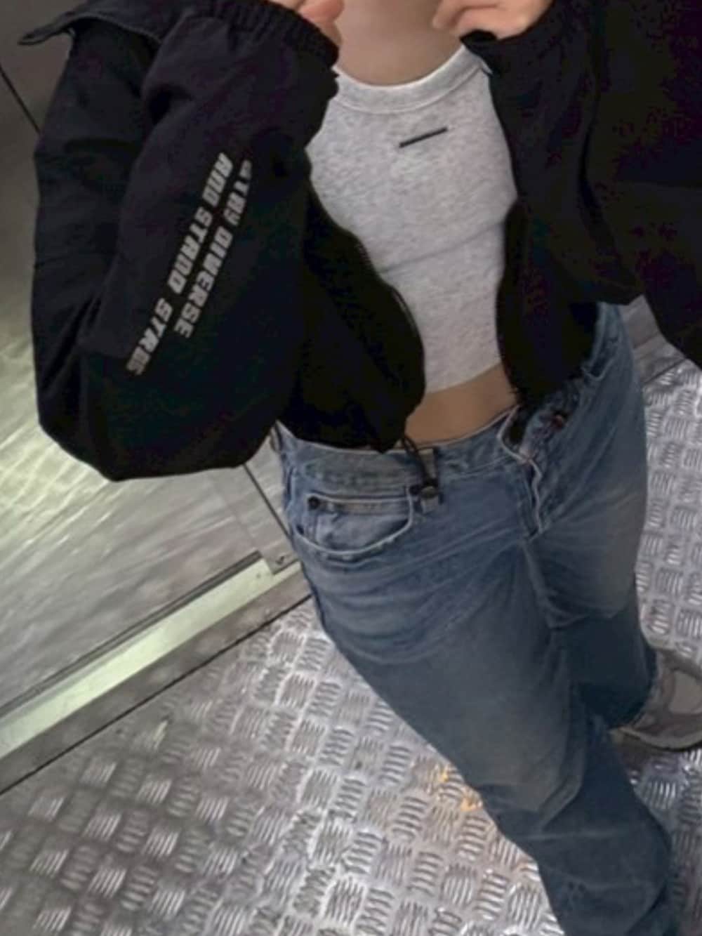 ブルー系のデニムパンツ、グレー系のタンクトップ、ブラック系のトップスを着用したレディースの夏コーディネートの2枚目の写真