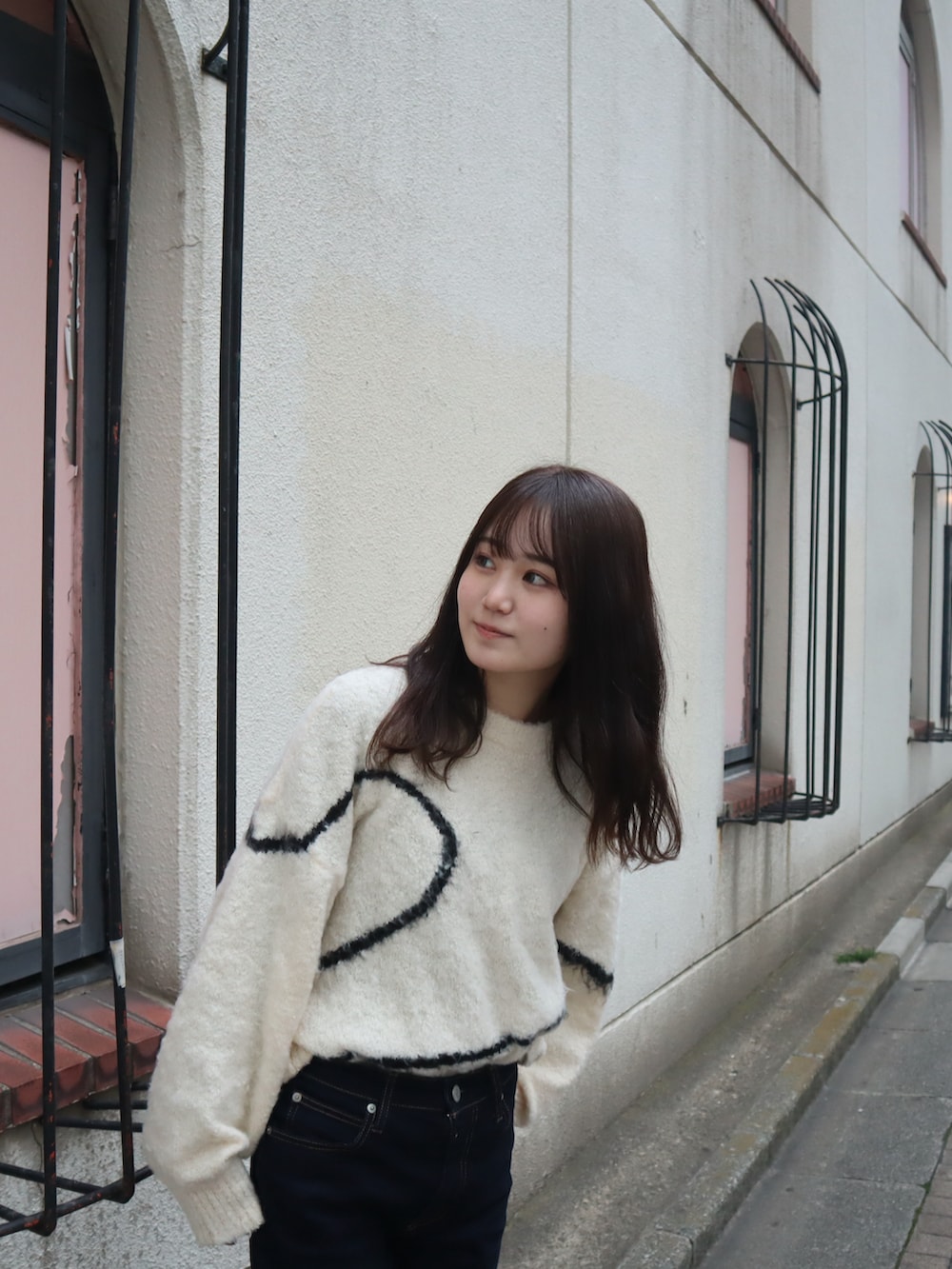 ホワイト系のニット/セーター、ブルー系のデニムパンツを着用したレディースの春コーディネートの2枚目の写真