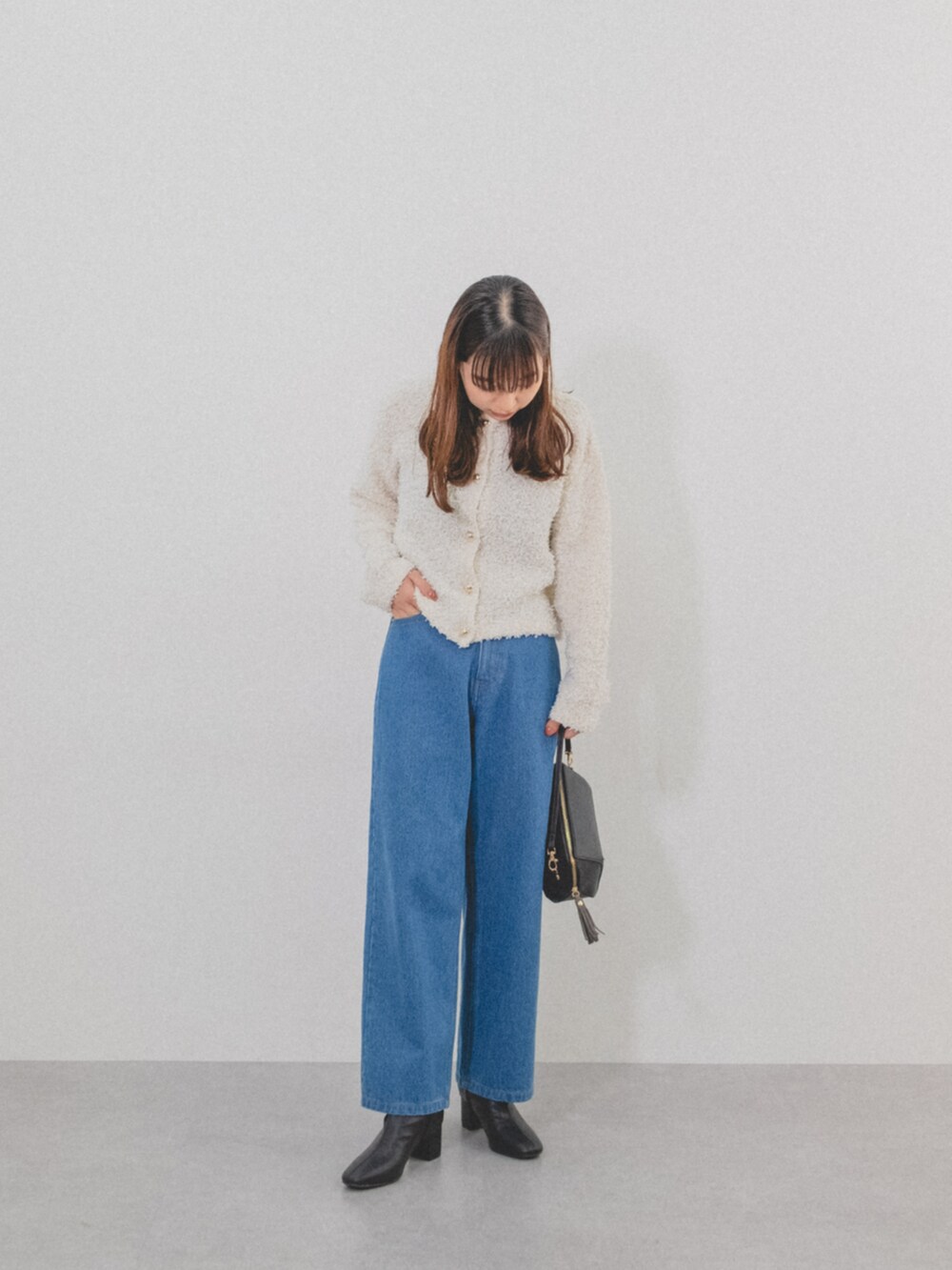 ホワイト系のカーディガン/ボレロ、ブルー系のパンツを着用したレディースの秋コーディネートの3枚目の写真