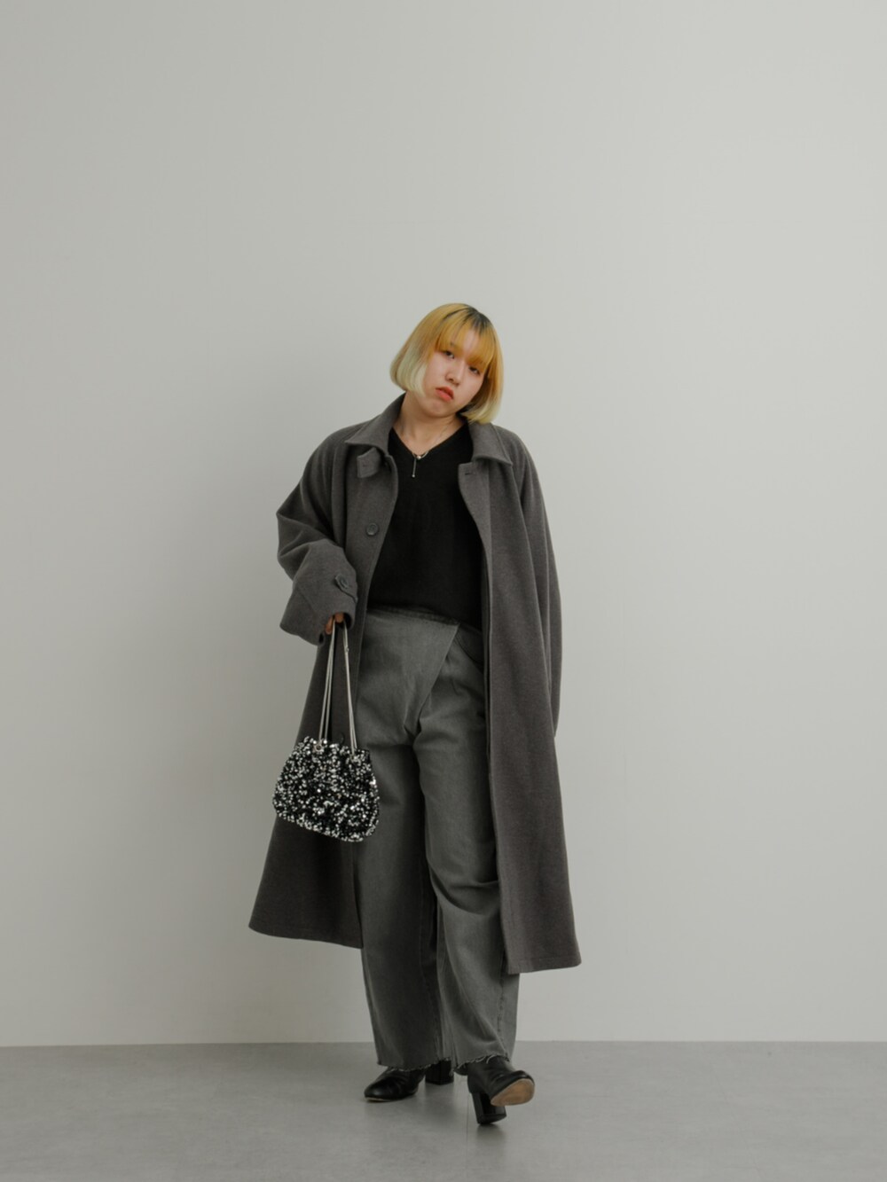 グレー系のジャケット/アウター、ブラック系のニット/セーター、グレー系のパンツを着用したレディースの冬コーディネートの3枚目の写真