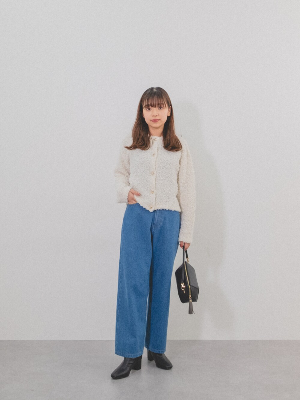 ホワイト系のカーディガン/ボレロ、ブルー系のパンツを着用したレディースの秋コーディネートの2枚目の写真