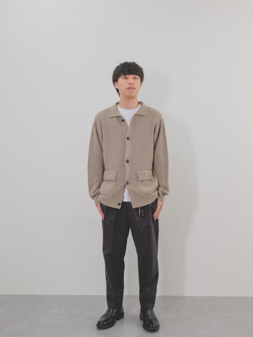ベージュ系のカーディガン/ボレロ、ホワイト系のTシャツ/カットソー、グレー系のパンツを着用したメンズの秋コーディネートの2枚目の写真