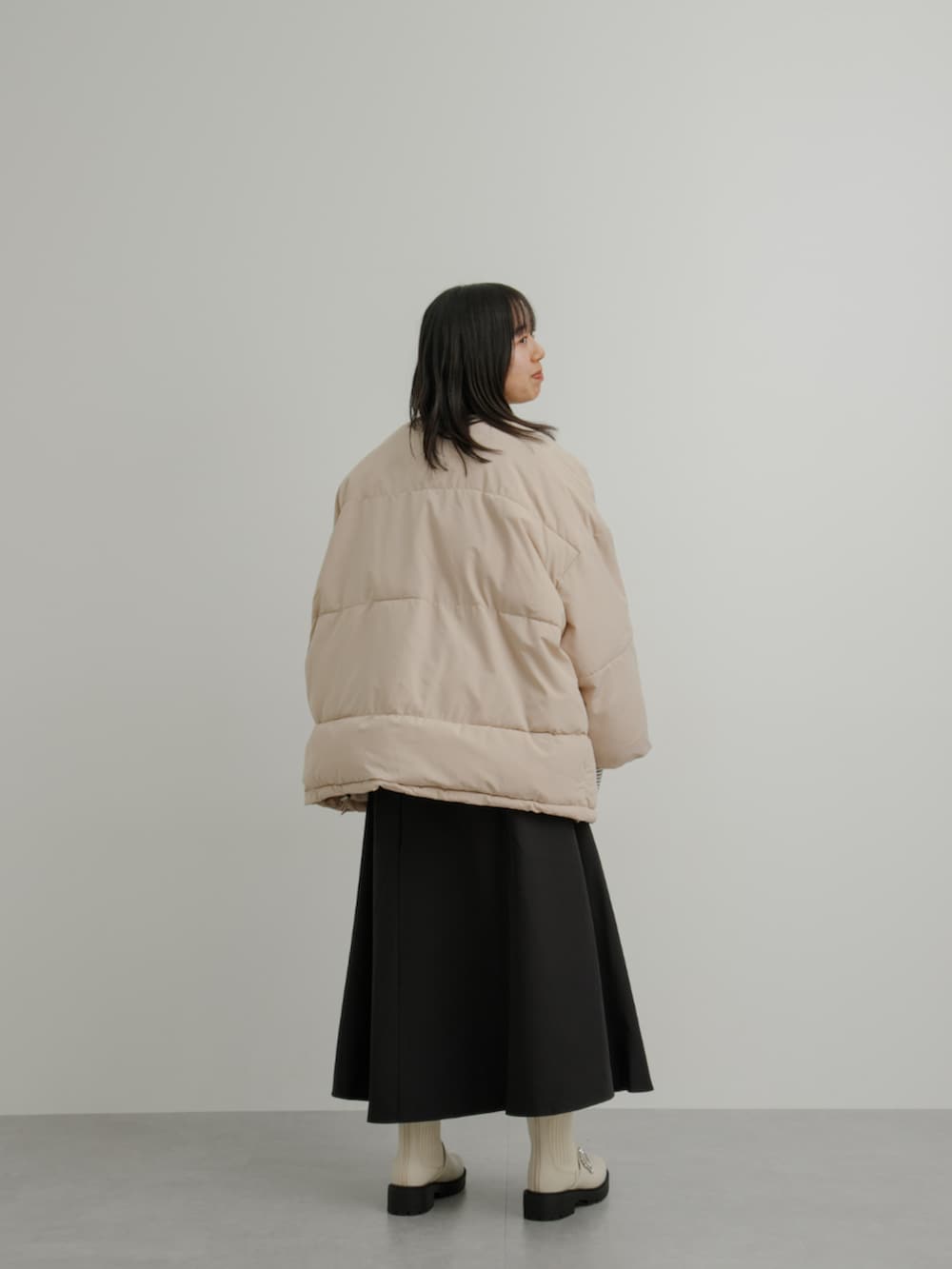 ベージュ系のジャケット/アウター、ホワイト系のTシャツ/カットソー、ブラック系のスカートを着用したレディースの冬コーディネートの3枚目の写真