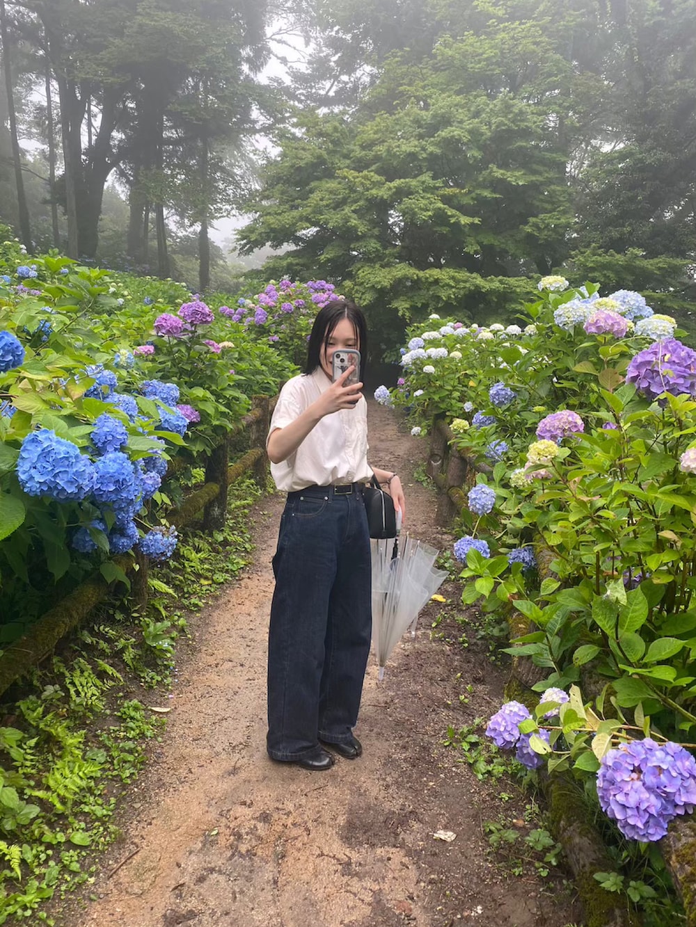 ホワイト系のシャツ/ブラウス、ブルー系のデニムパンツ、ブラック系のパンプスを着用したレディースの秋コーディネートの2枚目の写真