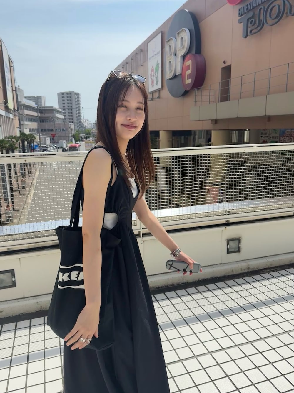 ブラック系のワンピース、ブラック系のスニーカー、ブラック系のトートバッグを着用したレディースの夏コーディネートの2枚目の写真