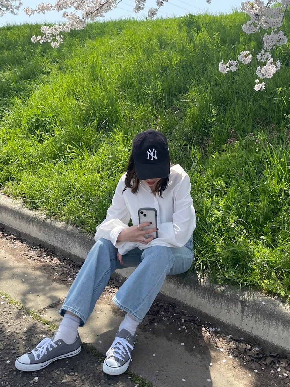 ホワイト系のシャツ/ブラウス、ブラック系のキャミソール、ブルー系のデニムパンツを着用したレディースの秋コーディネートの2枚目の写真