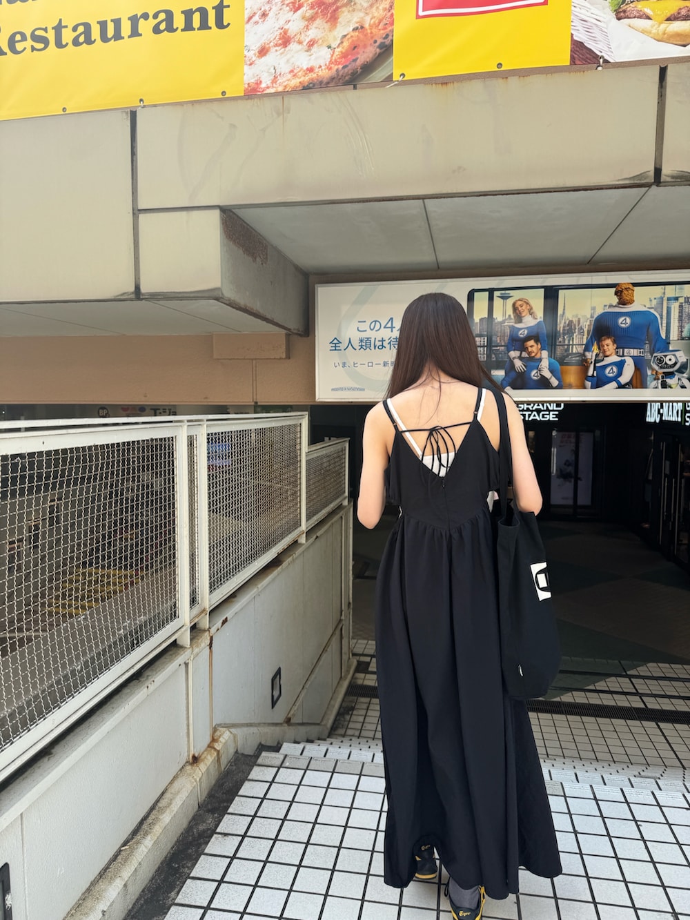 ブラック系のワンピース、ブラック系のスニーカー、ブラック系のトートバッグを着用したレディースの夏コーディネートの3枚目の写真