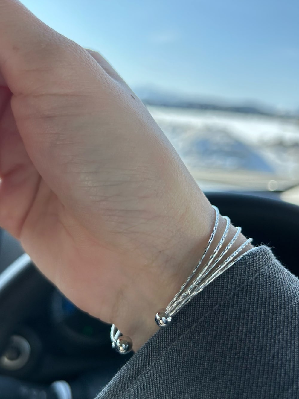 ブラック系のドレスシューズ、シルバー系のキャミソール、グレー系のテーラードジャケットを着用したレディースの冬コーディネートの4枚目の写真