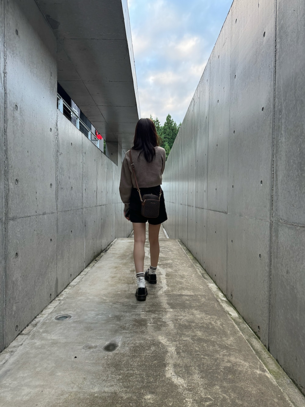 ブラウン系のニット/セーター、ブラック系のその他パンツ、ブラウン系のショルダーバッグを着用したレディースの秋コーディネートの2枚目の写真