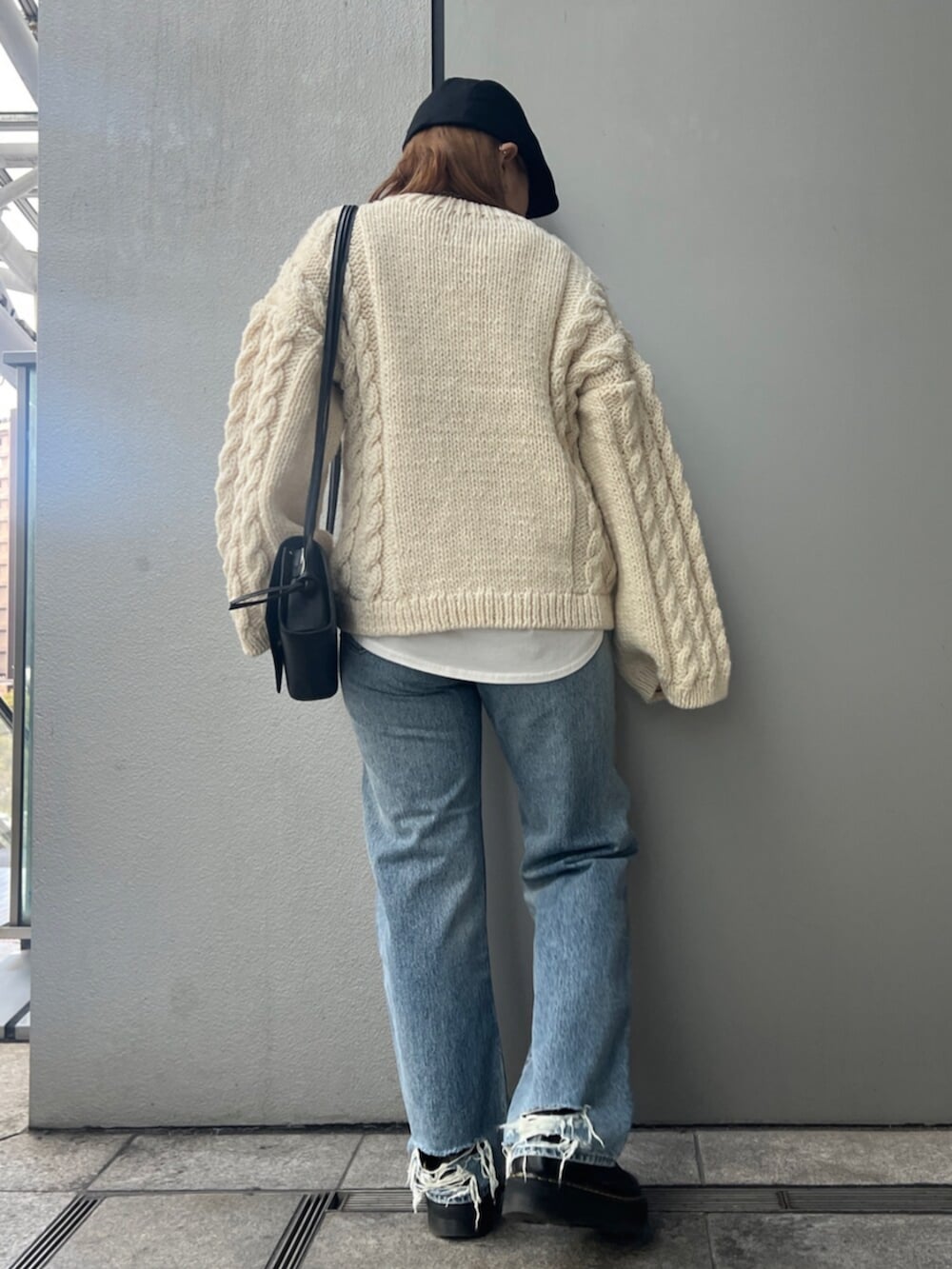 ホワイト系のTシャツ/カットソー、ホワイト系のニット/セーター、ブルー系のデニムパンツを着用したレディースの冬コーディネートの4枚目の写真