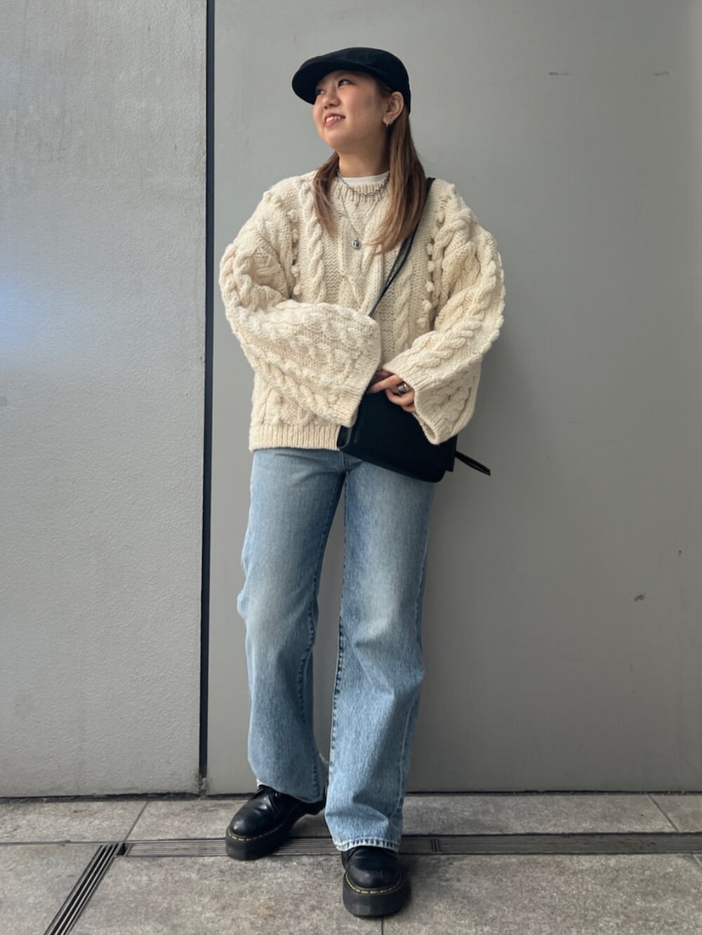 ホワイト系のTシャツ/カットソー、ホワイト系のニット/セーター、ブルー系のデニムパンツを着用したレディースの冬コーディネートの2枚目の写真