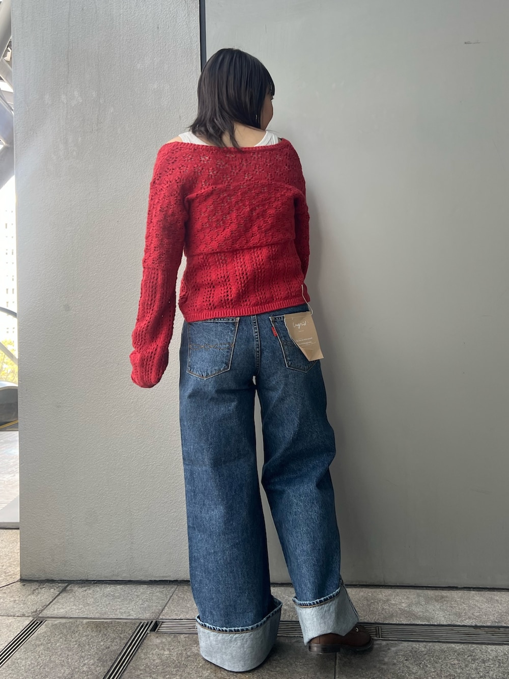 ブルー系のデニムパンツ、レッド系のカーディガン/ボレロ、ホワイト系のタンクトップを着用したレディースの冬コーディネートの2枚目の写真