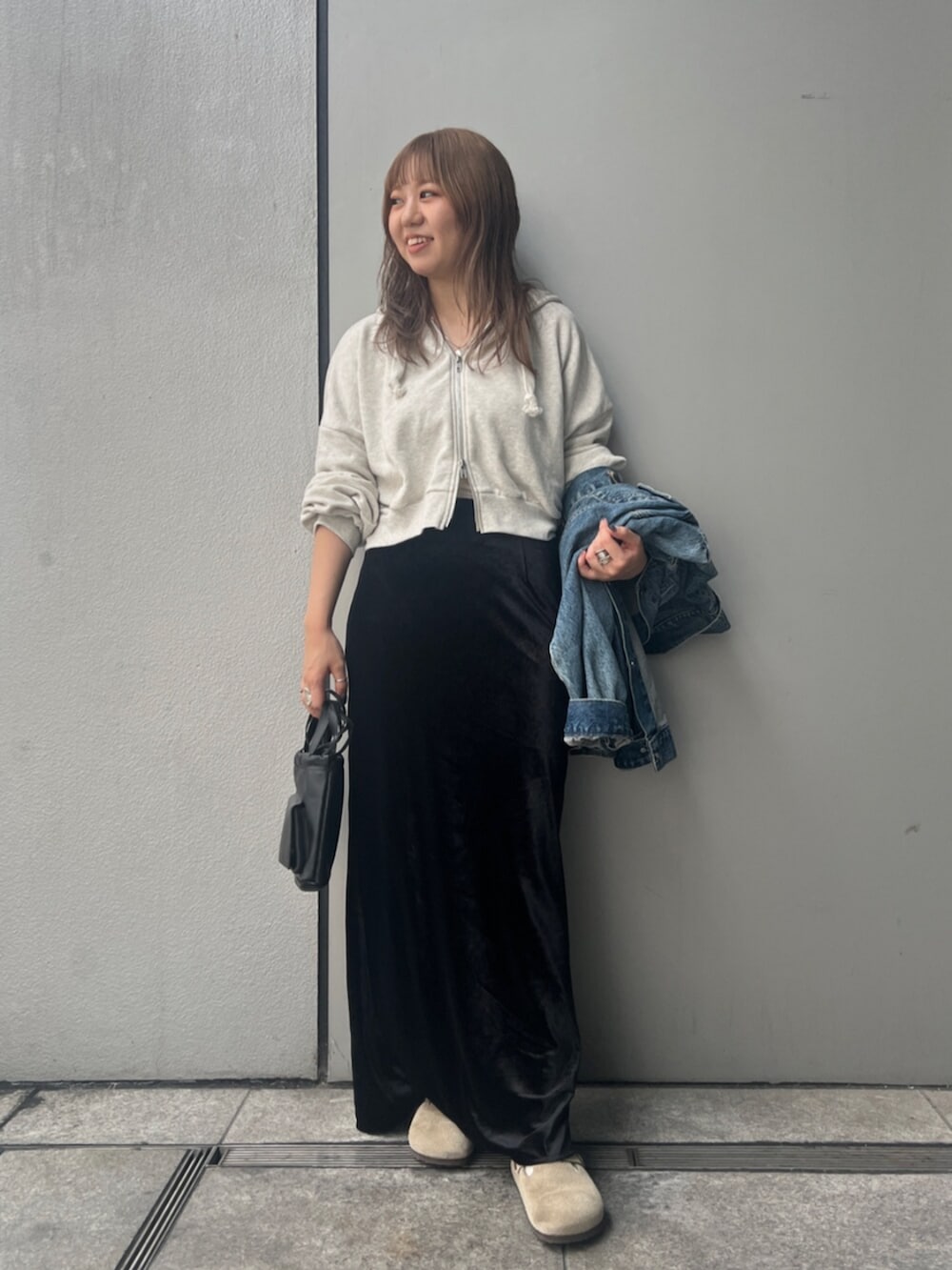 ホワイト系のパーカー、ブルー系のデニムジャケット、ブラック系のスカートを着用したレディースの秋コーディネートの5枚目の写真