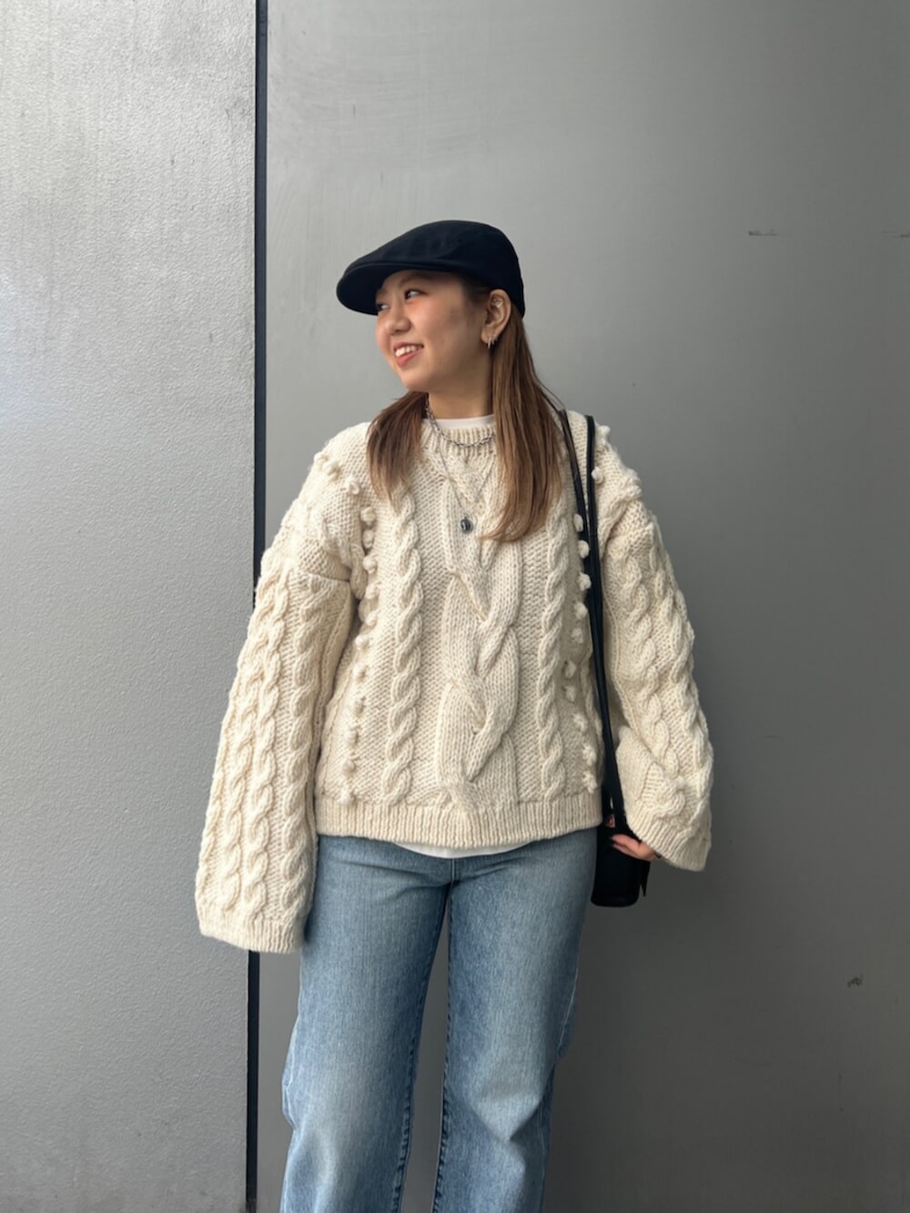 ホワイト系のTシャツ/カットソー、ホワイト系のニット/セーター、ブルー系のデニムパンツを着用したレディースの冬コーディネートの5枚目の写真