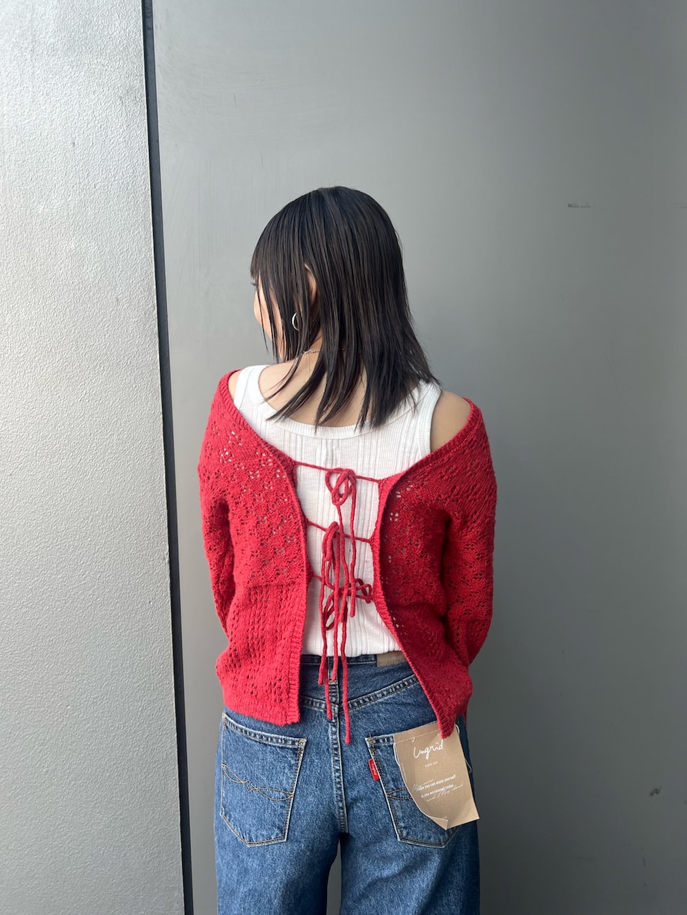 ブルー系のデニムパンツ、レッド系のカーディガン/ボレロ、ホワイト系のタンクトップを着用したレディースの冬コーディネートの8枚目の写真