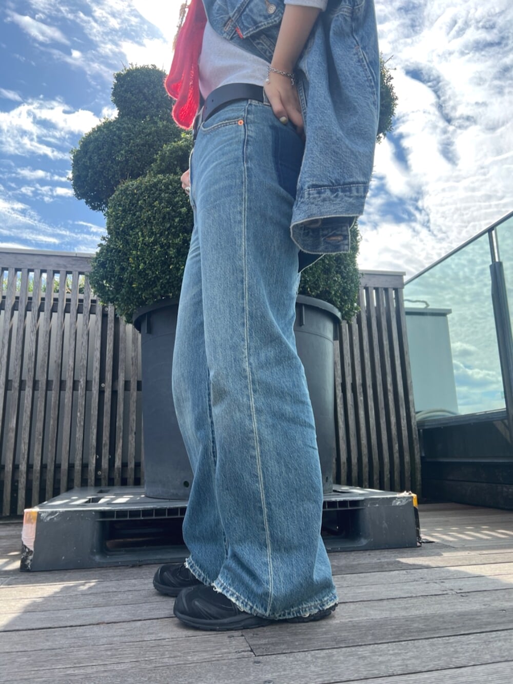 ブルー系のデニムパンツ、ブルー系のデニムジャケット、グレー系のTシャツ/カットソーを着用したレディースの秋コーディネートの4枚目の写真