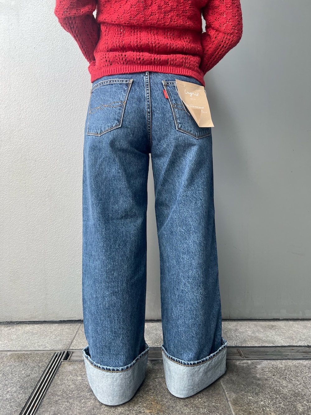 ブルー系のデニムパンツ、レッド系のカーディガン/ボレロ、ホワイト系のタンクトップを着用したレディースの冬コーディネートの6枚目の写真