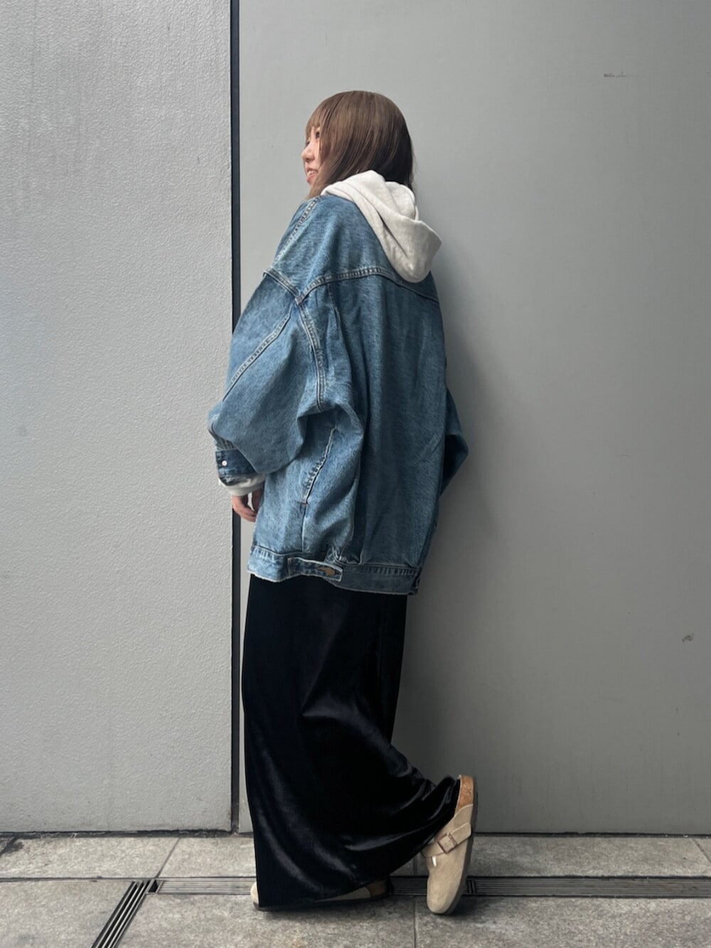 ホワイト系のパーカー、ブルー系のデニムジャケット、ブラック系のスカートを着用したレディースの秋コーディネートの3枚目の写真