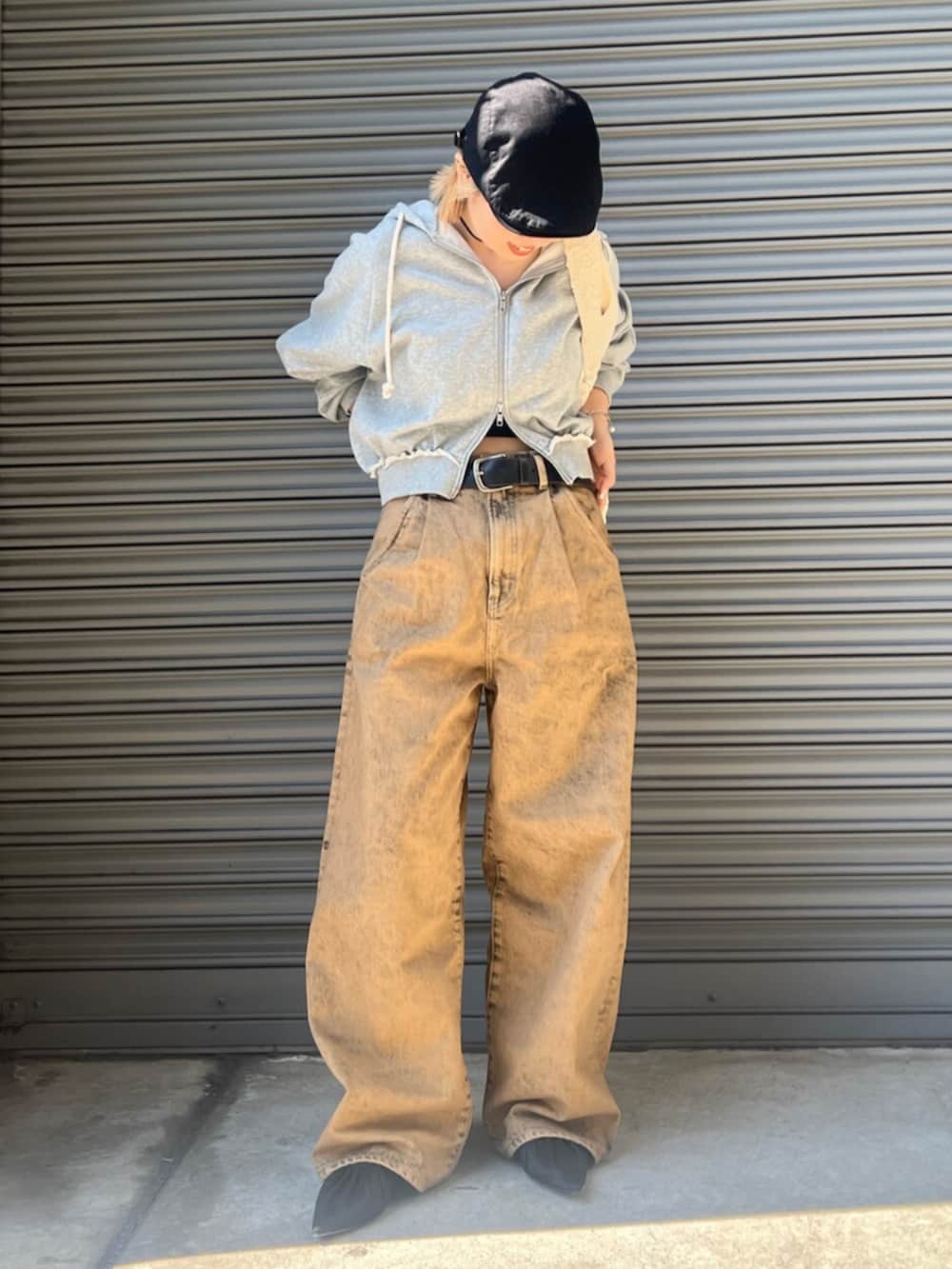 ブラック系のパンプス、ブラウン系のデニムパンツ、グレー系のパーカーを着用したレディースの春コーディネートの2枚目の写真