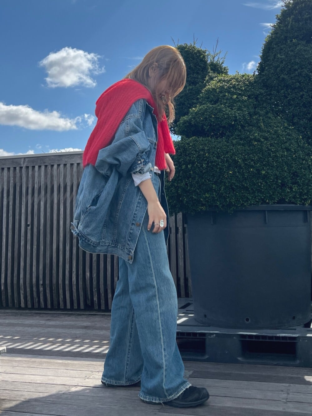 ブルー系のデニムパンツ、ブルー系のデニムジャケット、グレー系のTシャツ/カットソーを着用したレディースの秋コーディネートの2枚目の写真