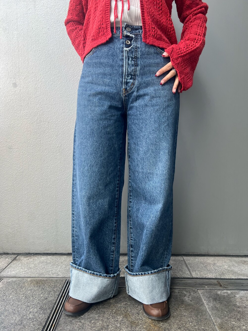 ブルー系のデニムパンツ、レッド系のカーディガン/ボレロ、ホワイト系のタンクトップを着用したレディースの冬コーディネートの5枚目の写真