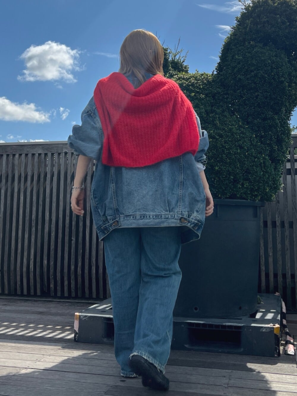 ブルー系のデニムパンツ、ブルー系のデニムジャケット、グレー系のTシャツ/カットソーを着用したレディースの秋コーディネートの3枚目の写真