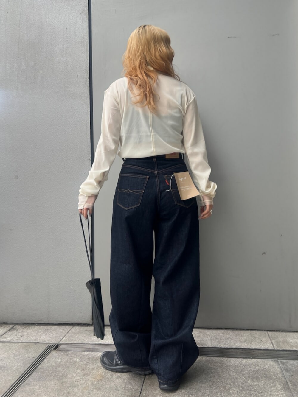 ホワイト系のTシャツ/カットソー、ブルー系のデニムパンツ、ブラック系のショルダーバッグを着用したレディースの冬コーディネートの3枚目の写真