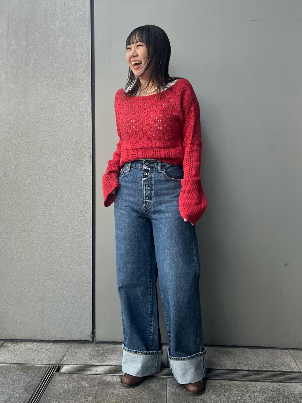 ブルー系のデニムパンツ、レッド系のカーディガン/ボレロ、ホワイト系のタンクトップを着用したレディースの冬コーディネートの7枚目の写真