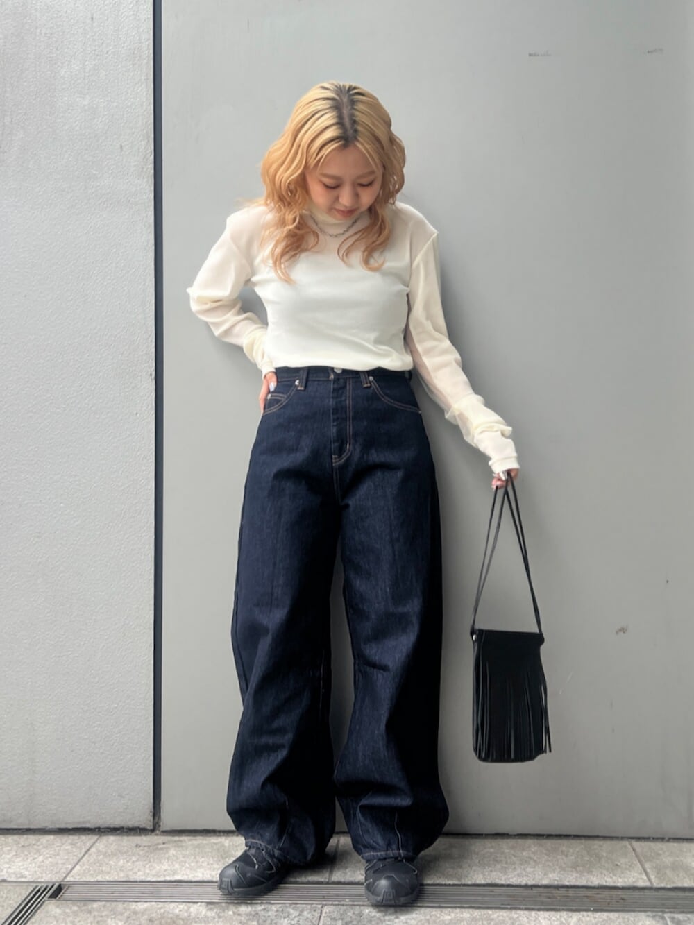 ホワイト系のTシャツ/カットソー、ブルー系のデニムパンツ、ブラック系のショルダーバッグを着用したレディースの冬コーディネートの4枚目の写真