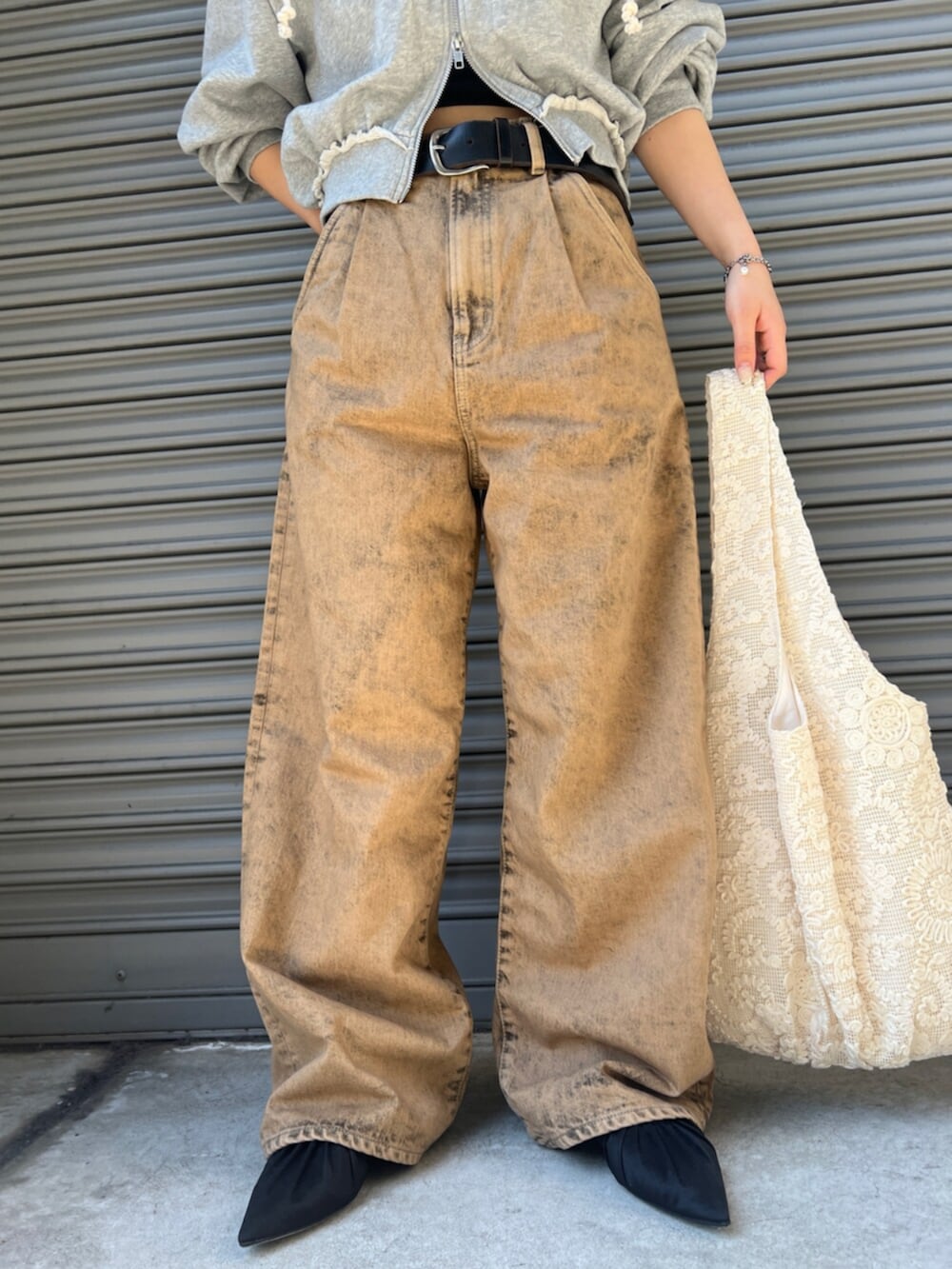 ブラック系のパンプス、ブラウン系のデニムパンツ、グレー系のパーカーを着用したレディースの春コーディネートの5枚目の写真