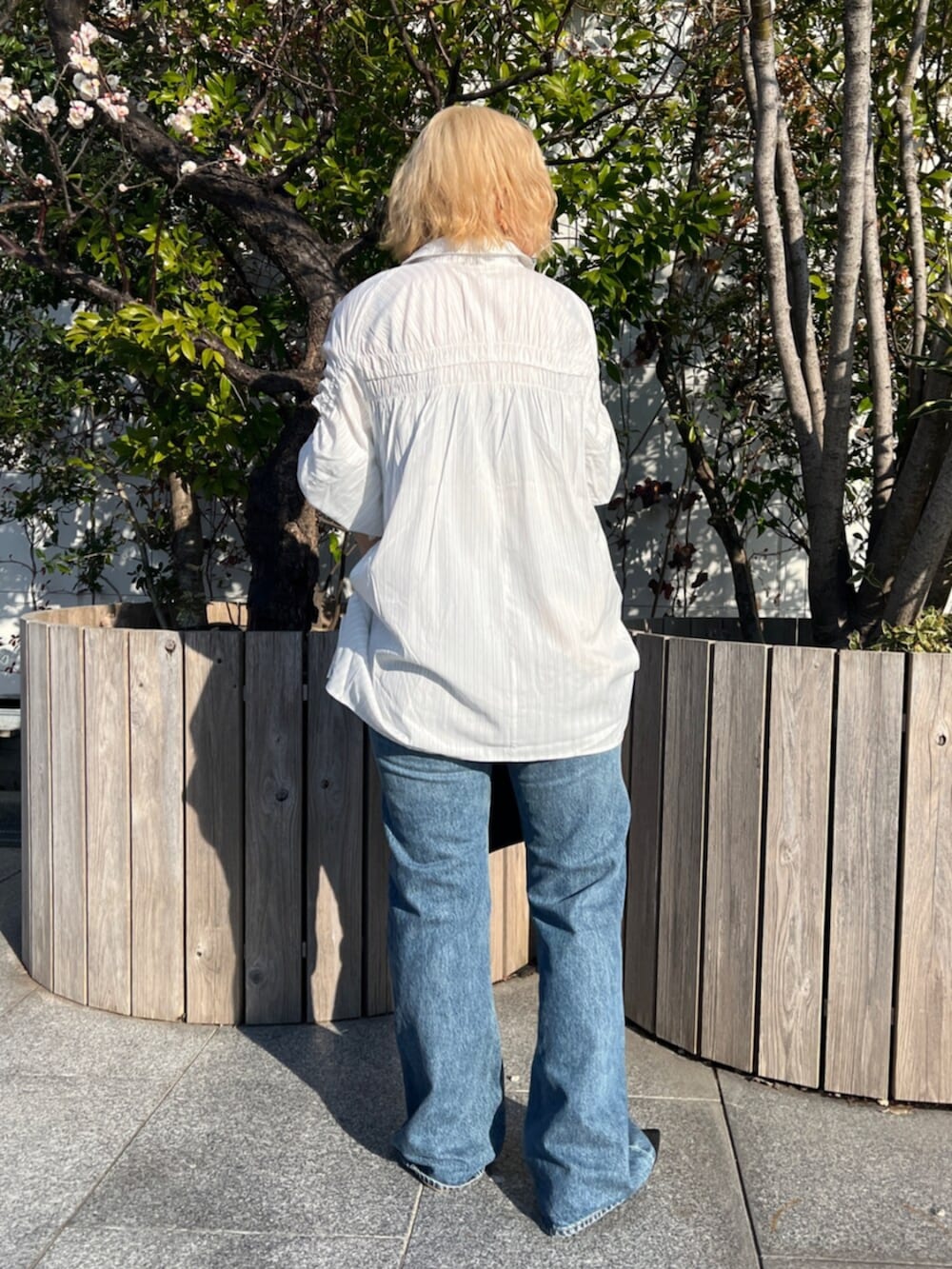 ブラック系のパンプス、ホワイト系のシャツ/ブラウス、ブルー系のデニムパンツを着用したレディースの春コーディネートの3枚目の写真