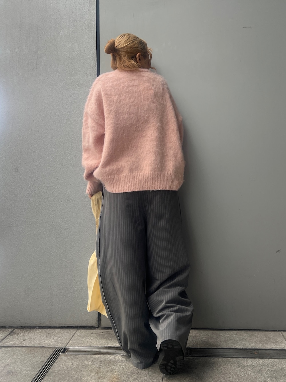 ピンク系のニット/セーター、イエロー系のトートバッグ、グレー系のその他パンツを着用したレディースの冬コーディネートの3枚目の写真