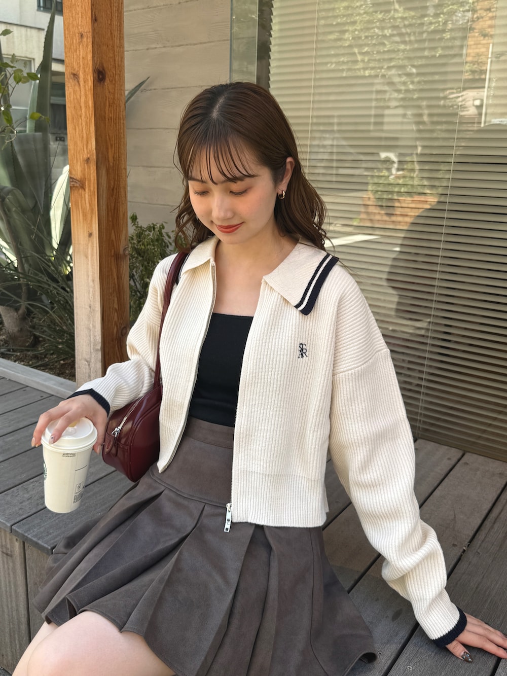 ホワイト系のニット/セーター、ブラウン系のスカートを着用したレディースの秋コーディネートの2枚目の写真