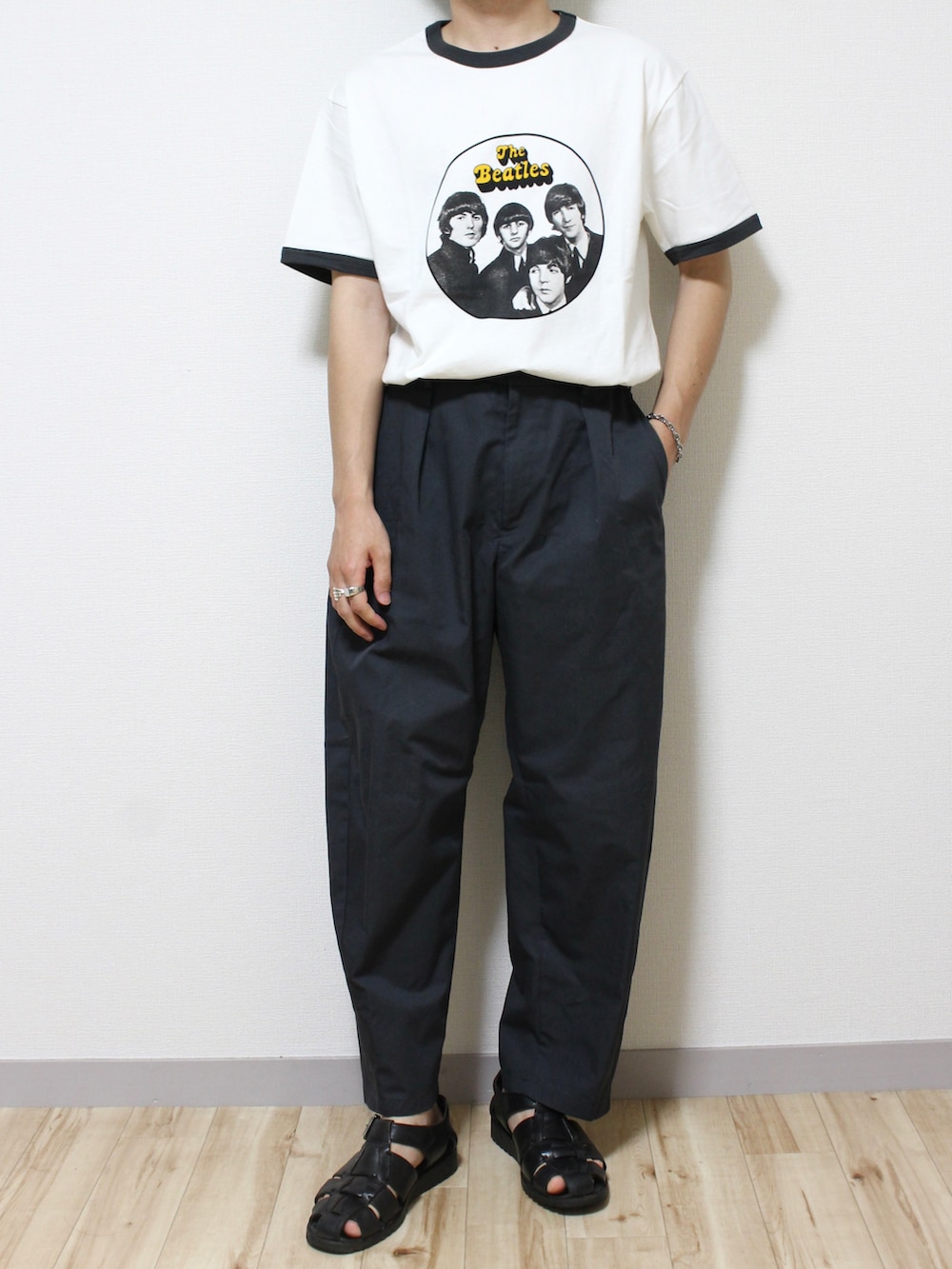 ブラック系のパンツ、ブラック系のサンダル、ホワイト系のTシャツ/カットソーを着用したメンズの夏コーディネートの2枚目の写真