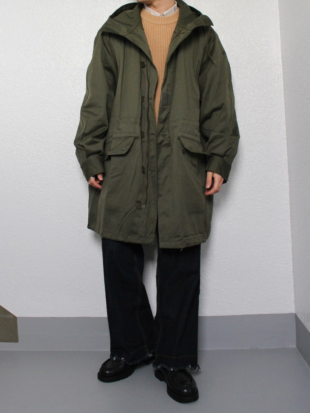 グリーン系のミリタリージャケット、ブルー系のデニムパンツ、ブラック系のドレスシューズを着用したメンズの冬コーディネートの3枚目の写真