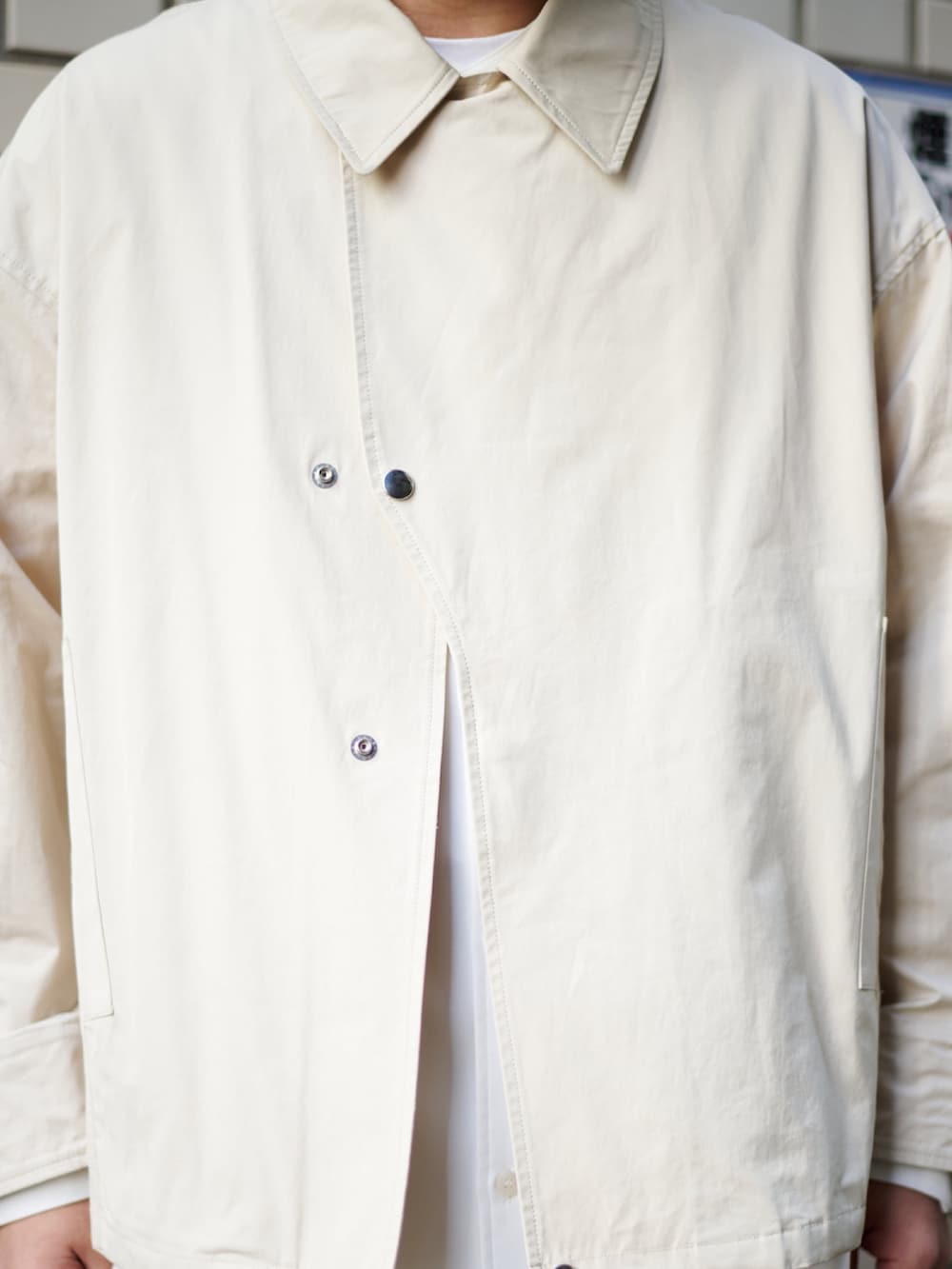 ベージュ系のブルゾン、ホワイト系のシャツ/ブラウス、ベージュ系のカーゴパンツを着用したメンズの春コーディネートの3枚目の写真